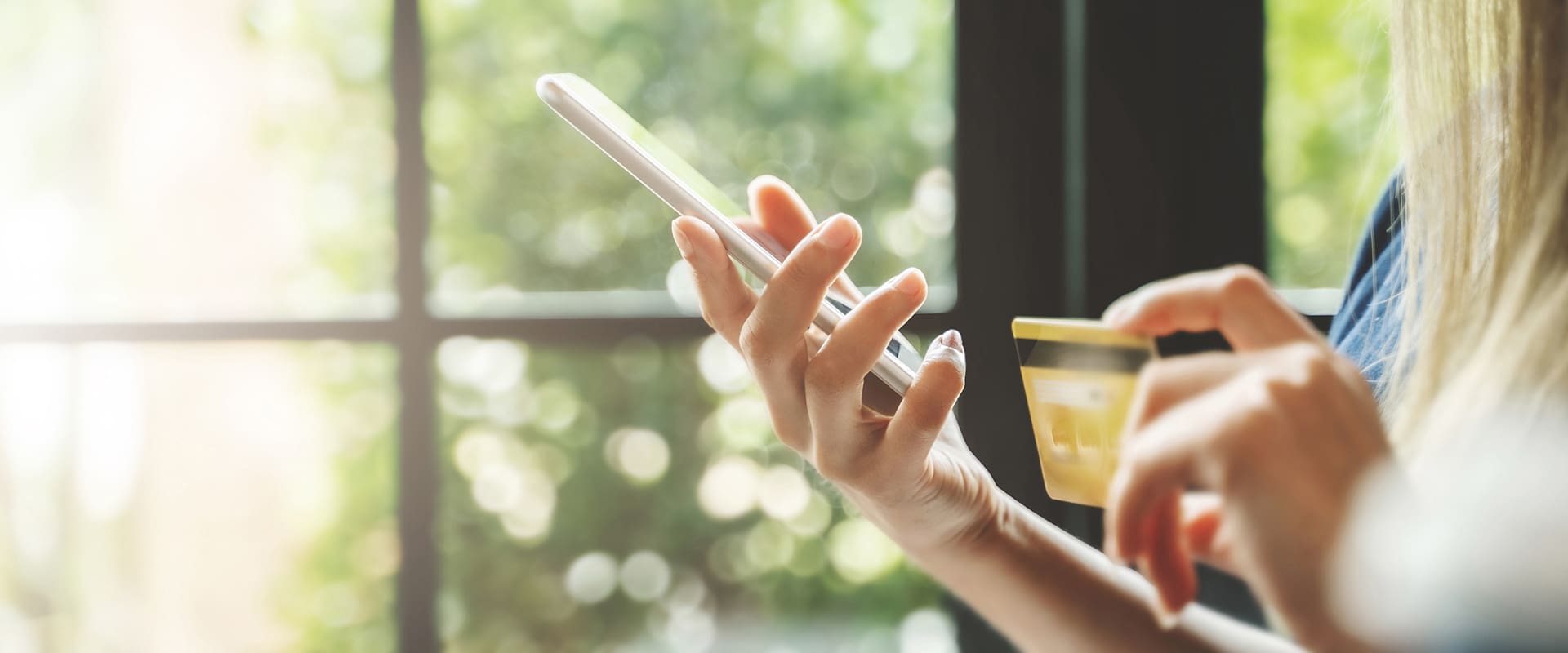 Close up hands of woman holding credit card shopping on website.